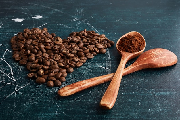 木のスプーンとハートの形のコーヒー豆。