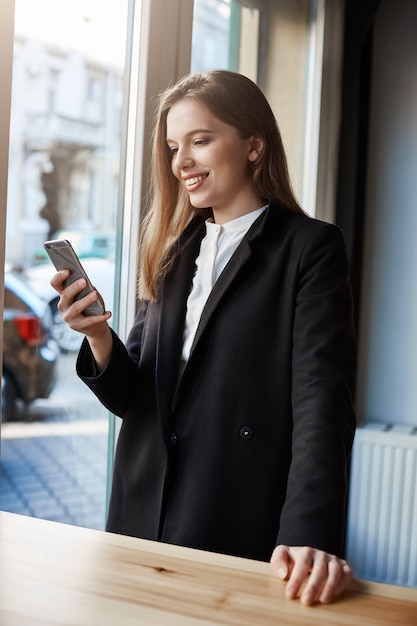 ビジネス前のコーヒー。カフェのカウンターの近くに立っているスタイリッシュな成功した都市の女性の肖像画