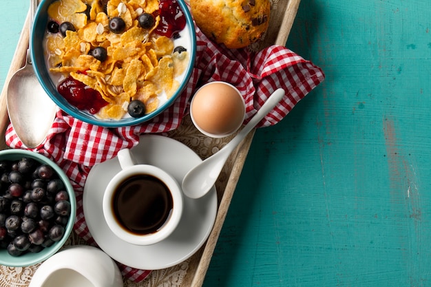 Coffee, berries and cereals on tray