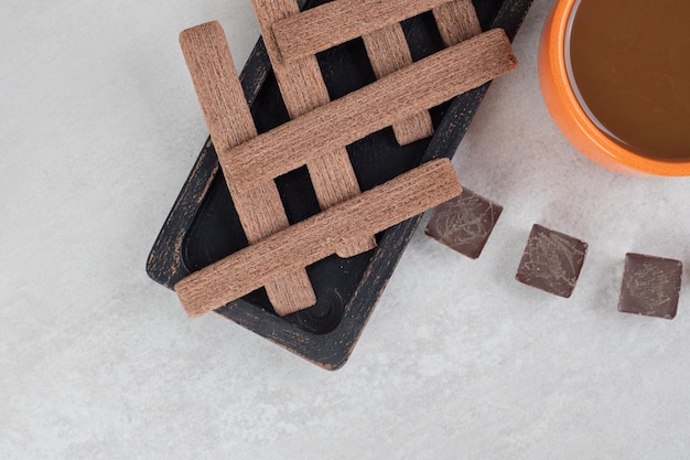 Foto gratuita caffè, biscotti e cioccolato fondente su superficie di marmo