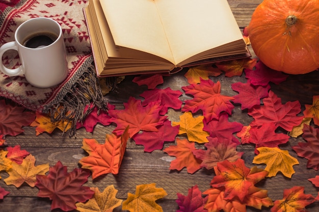 Coffee and blanket near book and pumpkin