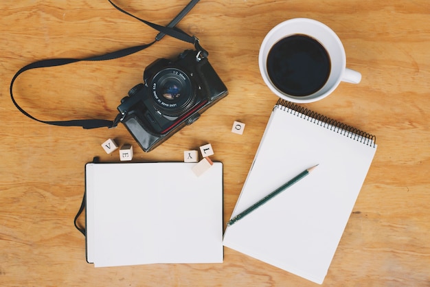 Coffee and camera near notebooks