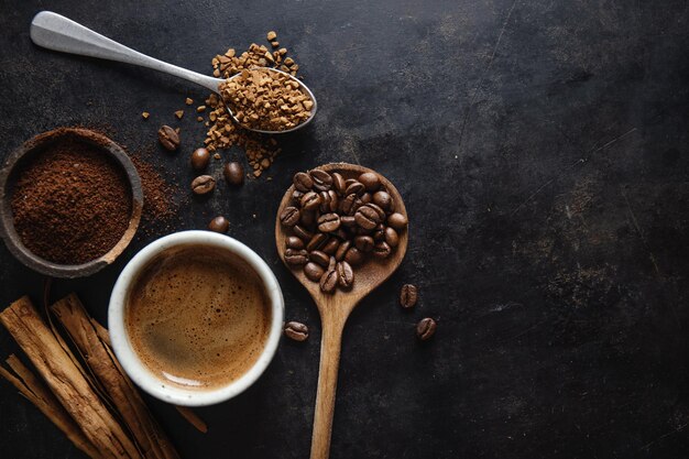 Coffee concept with differents types of coffee coffee beans milk and cinnamon sticks on grey background Flat lay