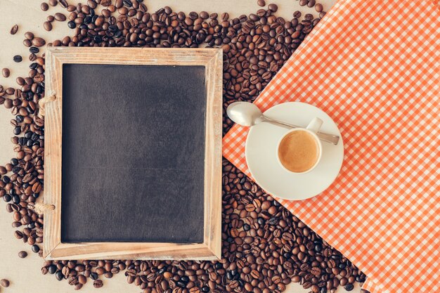 Концепция кофе со сланцем и чашкой на ткани