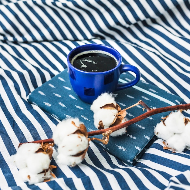 Free photo coffee and cotton on striped blanket