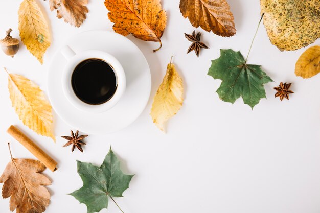 Coffee cup in arrangement with foliage