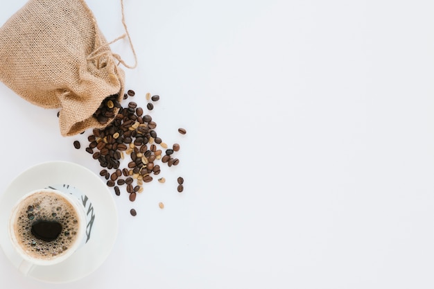 Free photo coffee cup and bag with coffee beans