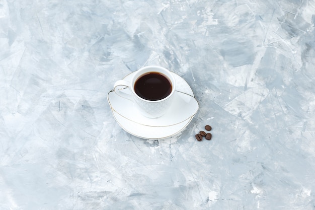 青い大理石の背景の上のカップのコーヒー。ハイアングルビュー。