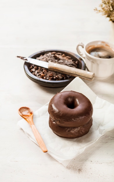 Coffee cup; chocolate donut on wooden backdrop