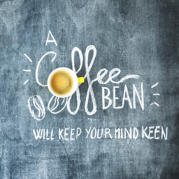 Free photo coffee cup over the coffee bean text on blackboard