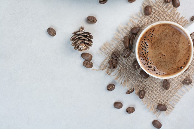 Free photo coffee cup and coffee beans on sackcloth . high quality photo