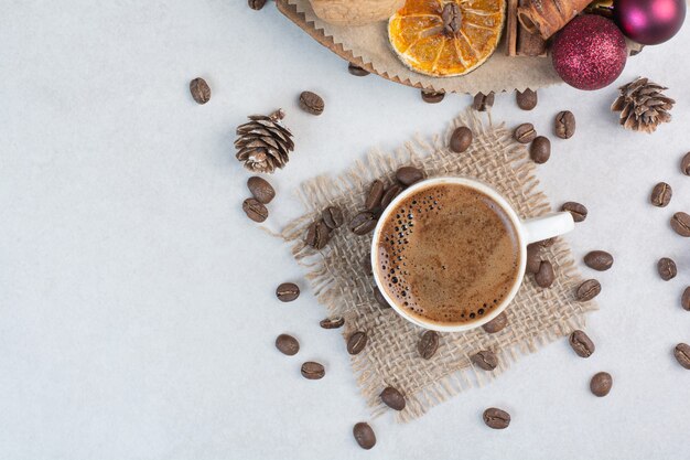 Чашка кофе и кофейные зерна на мешковине. Фото высокого качества