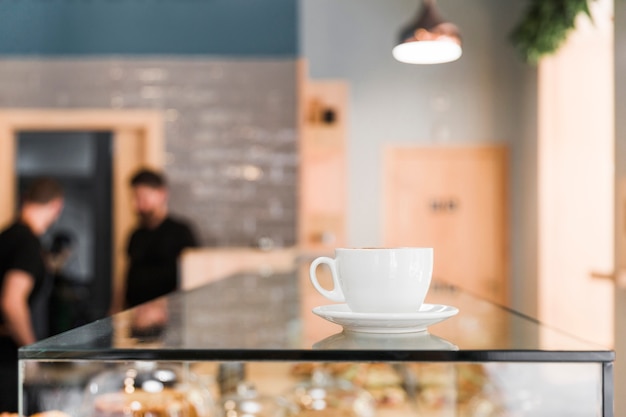 カフェショップのガラスカウンターでコーヒーカップ