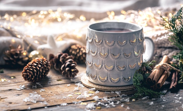 Coffee cup at home on a wooden table with bumps on a background with decorations winter mood holiday decoration magic Christmas