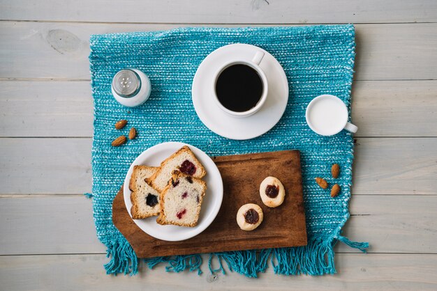 Coffee cup and pie with jam on table