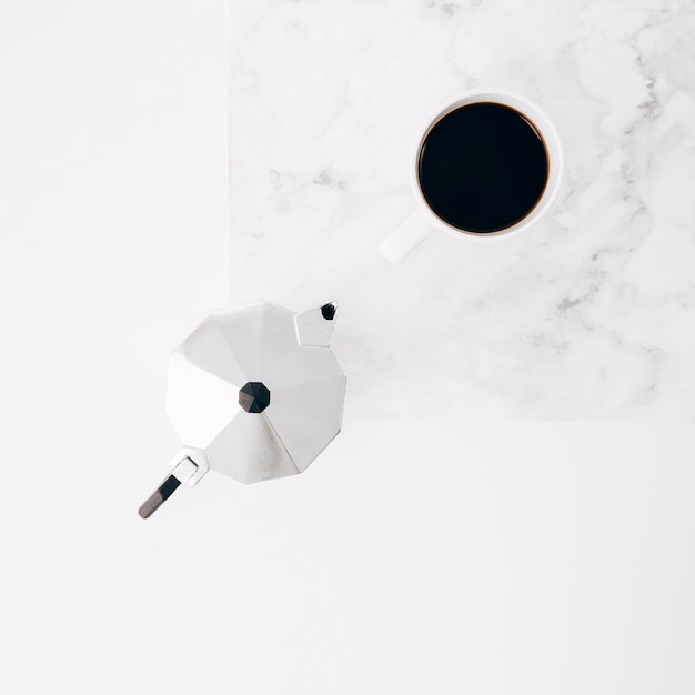 Coffee cup and pot on white textured background