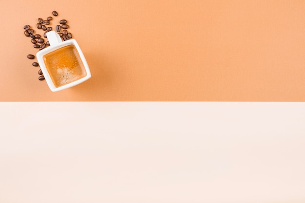 Coffee cup and roasted coffee beans on dual backdrop