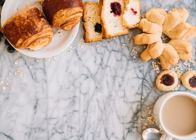 Coffee cup with bakery on marble table