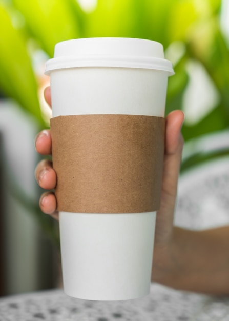 Free photo coffee cup with cardboard to catch it