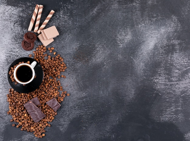 Кофейная чашка с кофе в зернах шоколада и печенье с копией пространства