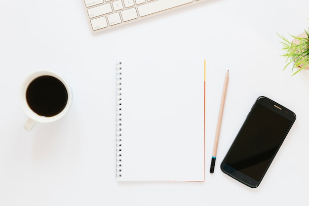 Coffee cup with notebook and phone