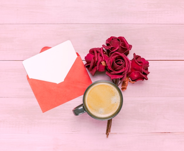 Coffee cup with red roses and envelope 