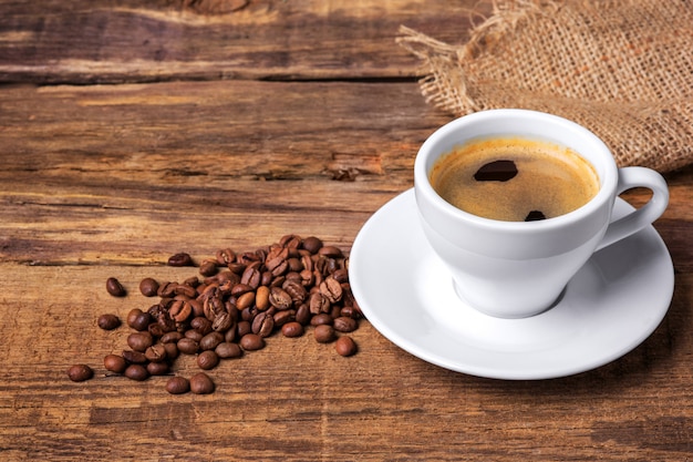 Coffee cup on a wooden table. Dark wall.