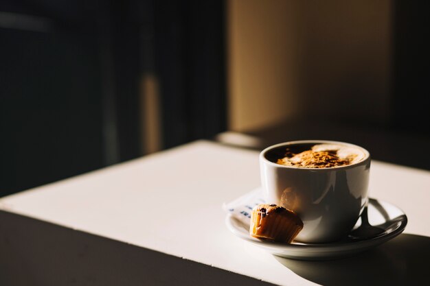 Coffee and cupcake on table