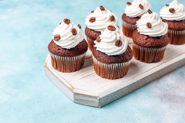 Coffee cupcakes decorated with whipped cream and coffee beans.