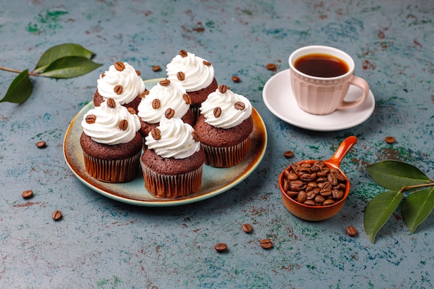 ホイップクリームとコーヒー豆で飾られたコーヒーカップケーキ。