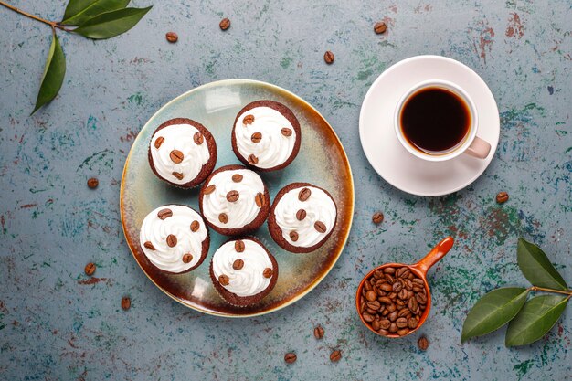 Coffee cupcakes decorated with whipped cream and coffee beans.