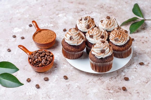 Free photo coffee cupcakes decorated with whipped cream and coffee beans.