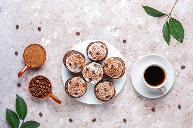 커피 컵 케이크는 휘핑 크림과 커피 콩으로 장식되어 있습니다.