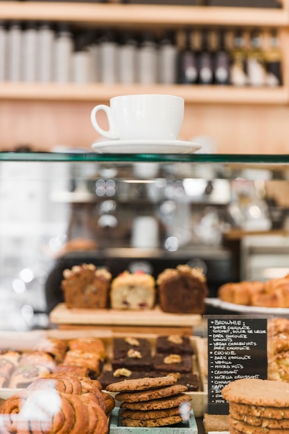 Coffee over glass cabinet with baked food