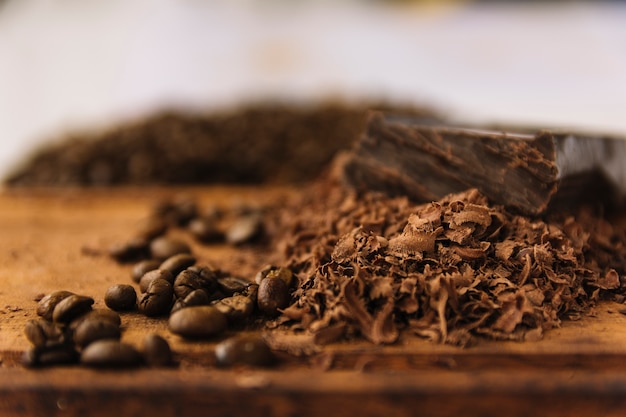 Coffee grains and chocolate curls on cutting board