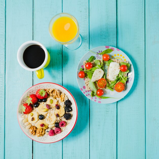 Coffee and juice near salad and muesli