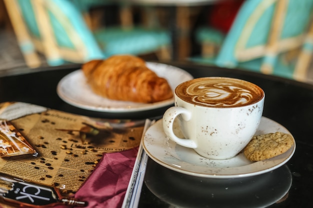 coffee latter with cookies croissant side view