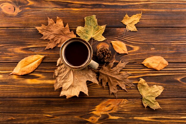 Coffee and leaves on wooden background 