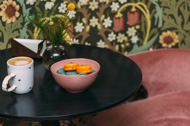 Coffee and macaroons on cafe table