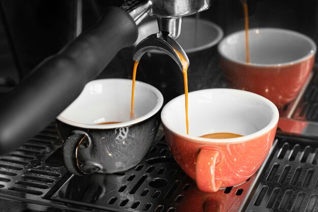 カップと機械でコーヒーを作る