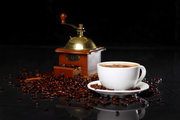 Coffee mill on the table with coffee beans around