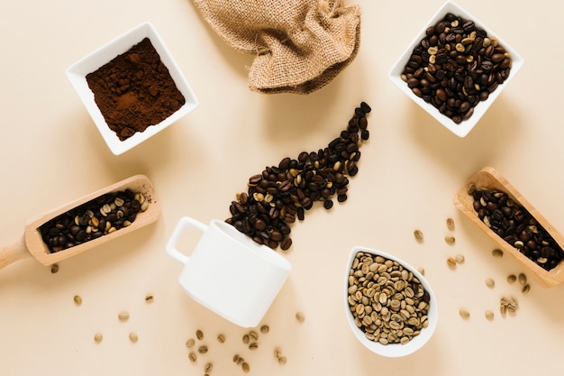 Foto gratuita tazza da caffè con caffè macinato e chicchi di caffè