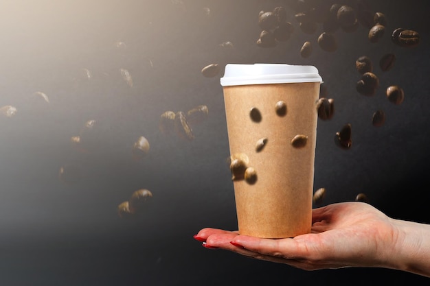 Coffee paper cups with coffee beans on a dark background. Pattern and creative background concept for cafes.