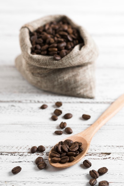 Free photo coffee roasted beans in burlap sack and spoon