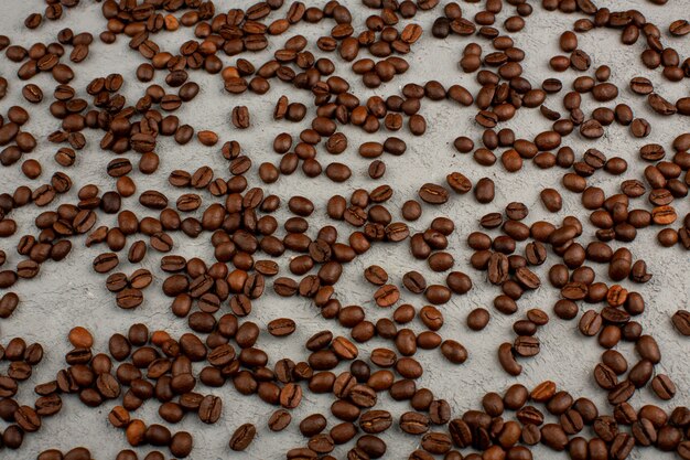 Кофейные семена коричневого цвета на сером столе