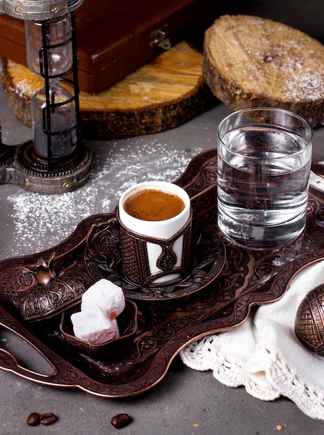 Foto gratuita caffè servito con prelibatezze turche e bicchiere d'acqua