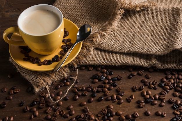 コーヒー豆の近くの荒布を着たコーヒー