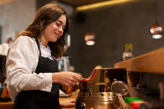 Impiegato della caffetteria che produce caffè