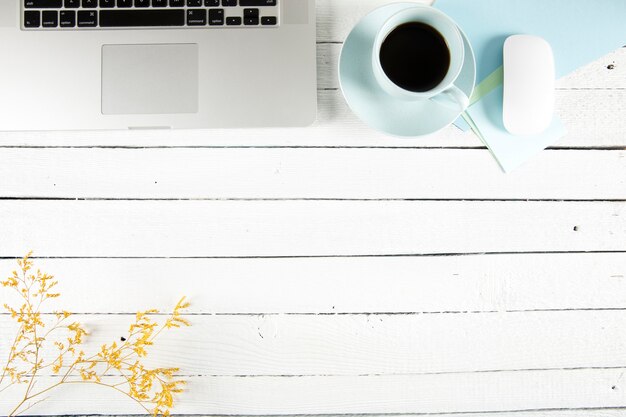 Coffee and twig near laptop on table