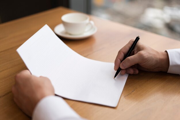 Coffee next to unrecognisable man writing